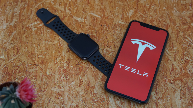 Apple Watch next to iPhone with Tesla logo