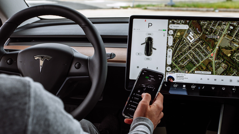 person using iPhone inside Tesla