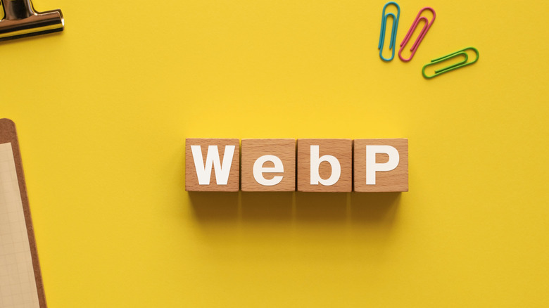 WebP written using wood blocks on a yellow surface and some paper clips