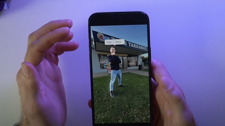 Person cutting out selfie on iPhone