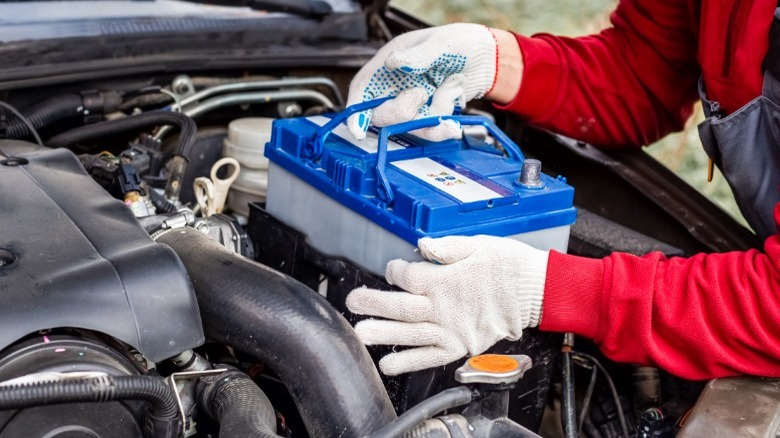 person installing car battery