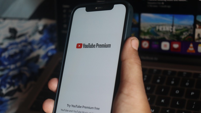 hand holding iPhone with Youtube Premium