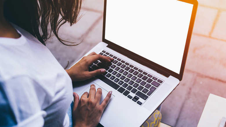 woman using macbook outdoors