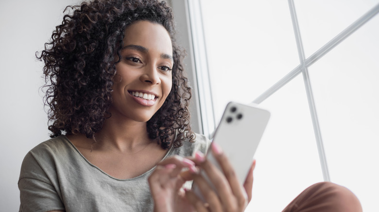 person smiling using iPhone