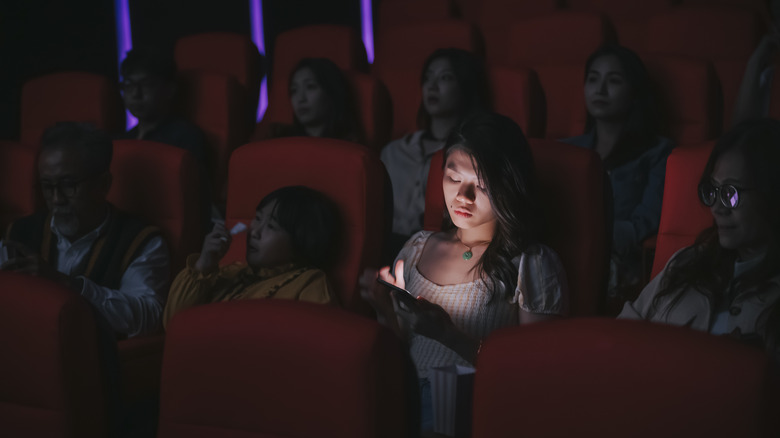 person using phone at the movies 