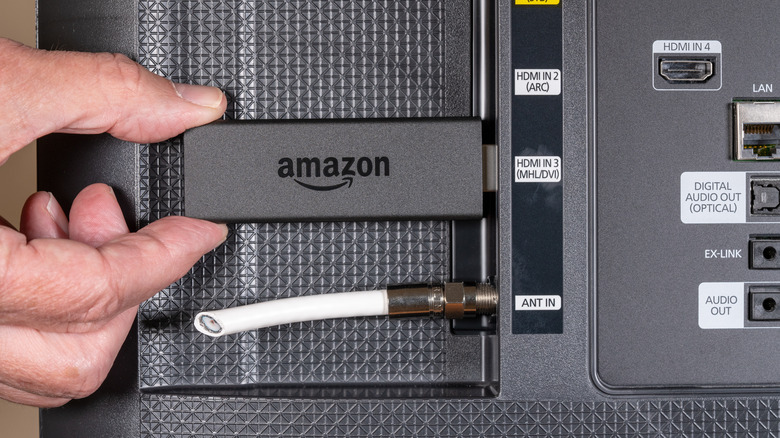 A Fire Stick being plugged into a TV