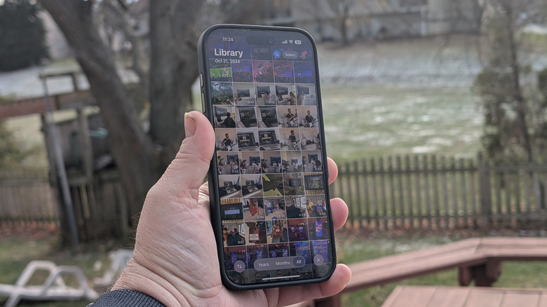 Man holding a phone with the photos app