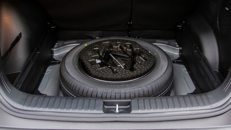 A spare tire in the trunk of a car