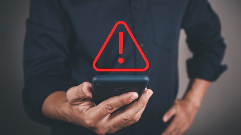 Man holding a phone with an error sign