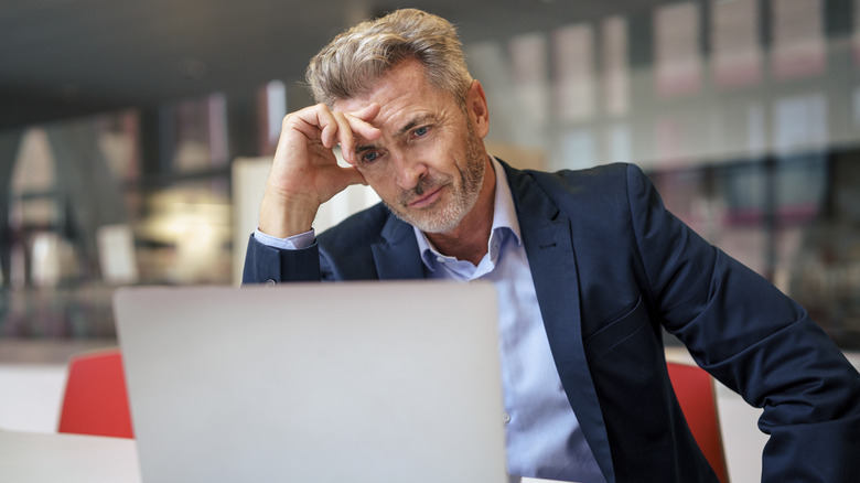 A frustrated man staring at laptop