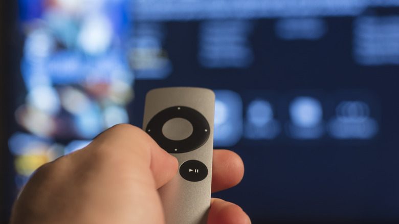 Person holding Apple TV remote