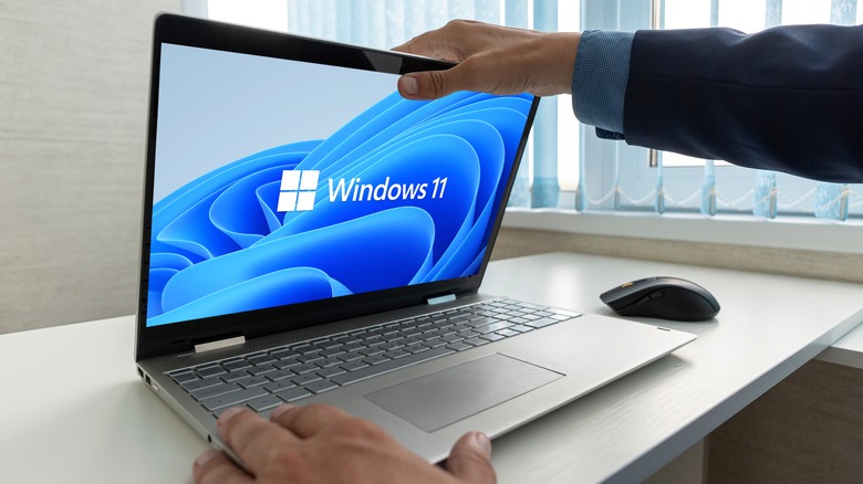 man opening windows 11 laptop