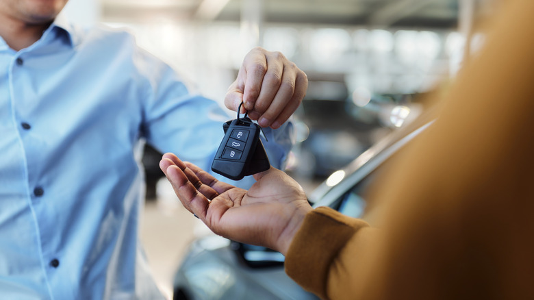 Person handing over keys to car