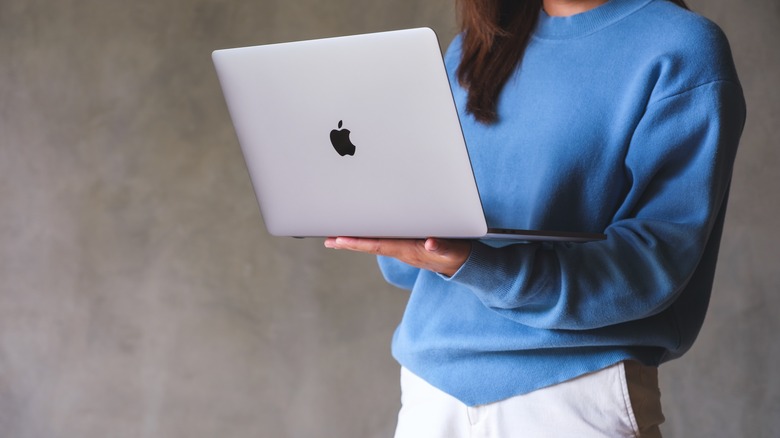 Woman holding MacBook Pro