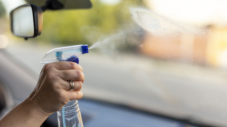 Spraying windshield with cleanser