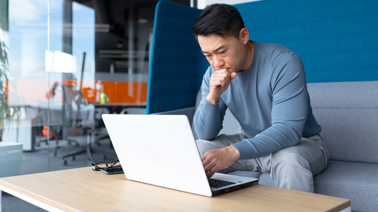 Man thinking in front of laptop