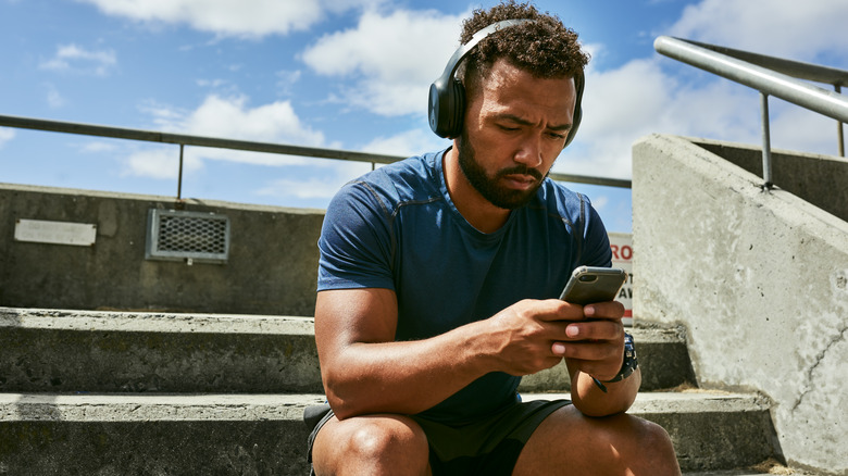 man listening to phone headphones