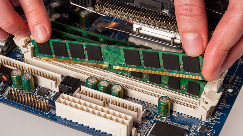 person aligning RAM stick motherboard