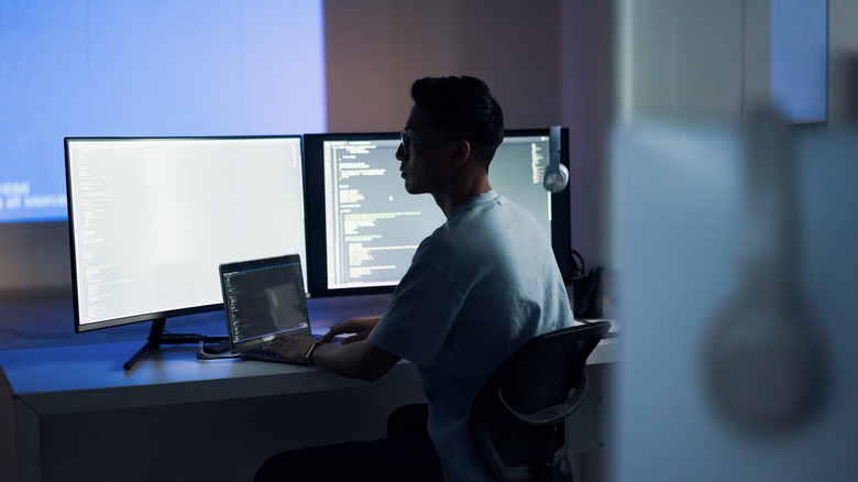 man working bright screens nighttime