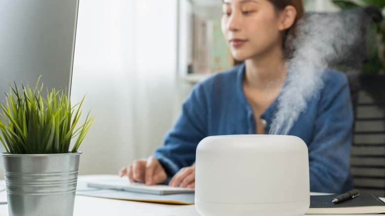 woman using humidifier on desk