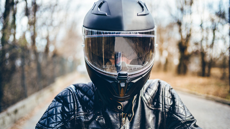 Man with helmet in leather jacket on motorcycle