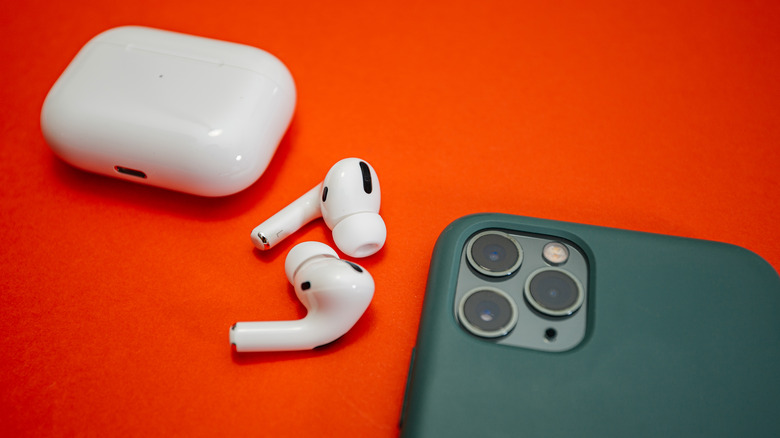 Airpods case next to iPhone