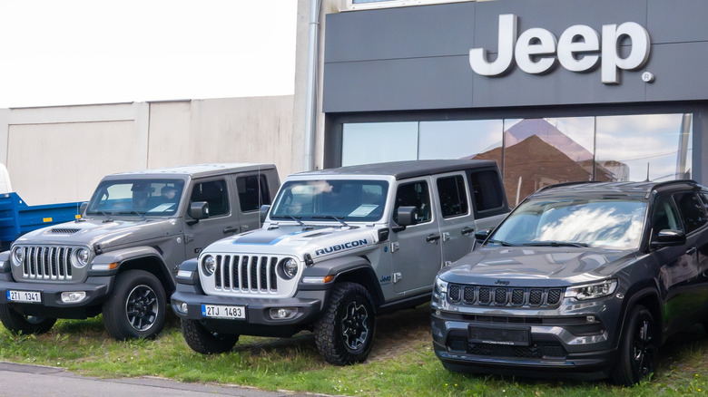 Jeep Compass and Rubicon SUV car in front of dealership