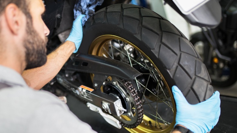 person replacing a motorcycle tire