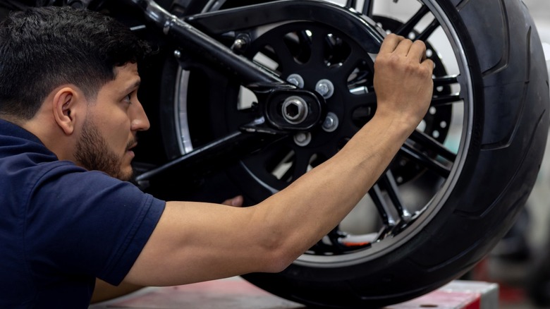 Man inspecting motorcycle tire