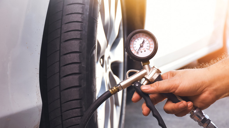 hand holding tire inflator next to wheel