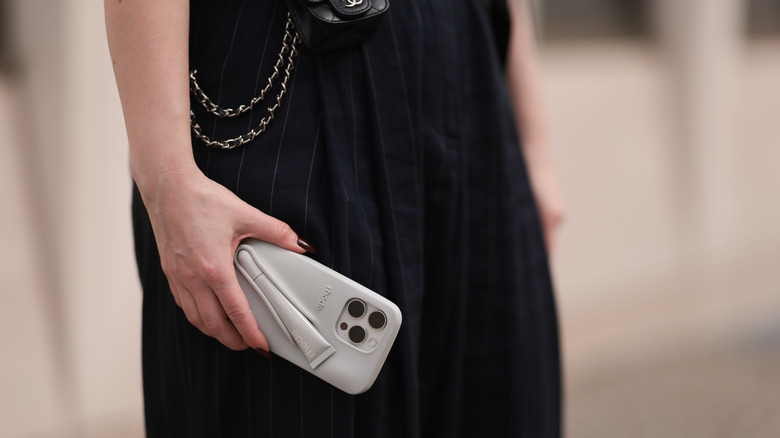 woman holding iPhone with rhode phone case