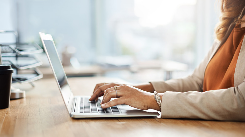 Person typing on laptop in kitchen