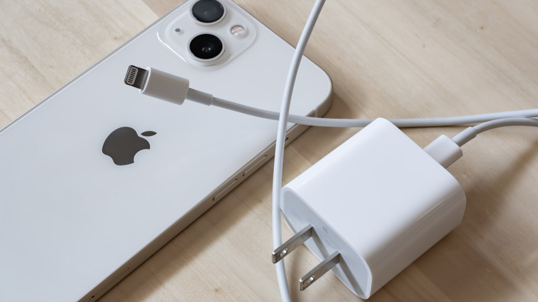 iPhone on table with charging brick and USB-C cable