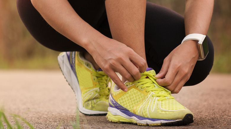 female runner tying shoes