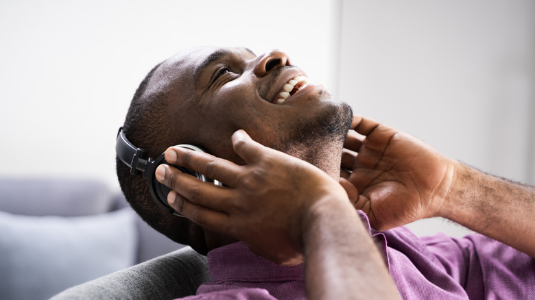 Smiling man listens to headphones