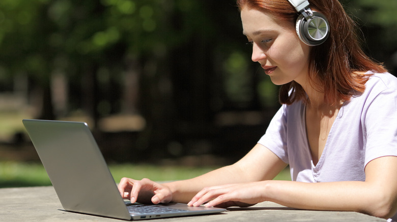 Woman using laptop in park