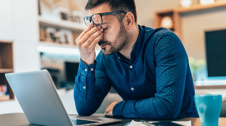 Man looking frustrated at laptop