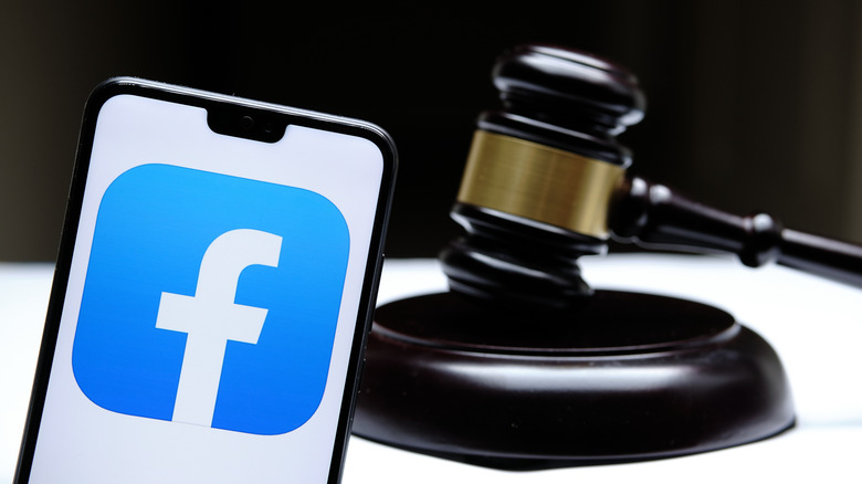 Facebook logo on smartphone next to gavel