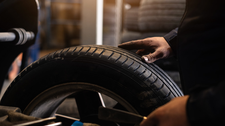 Large car tire being placed in storage