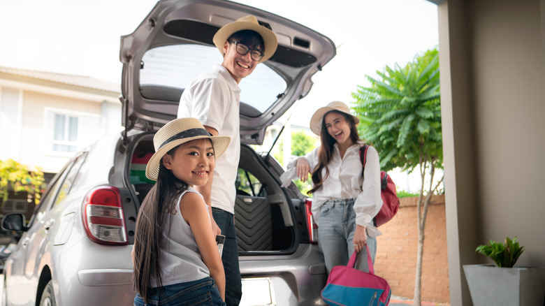 family standing in garage near car