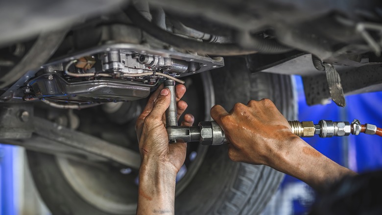 Mechanic working on car transmission