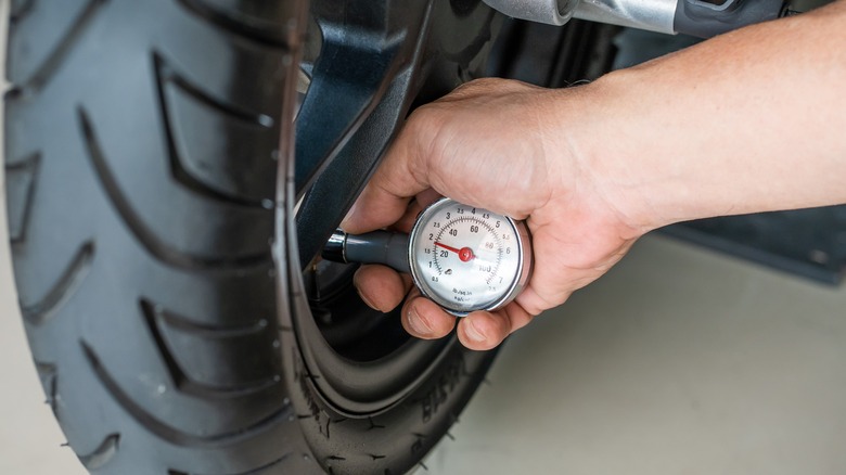 a man checking the tire pressure with a gauge