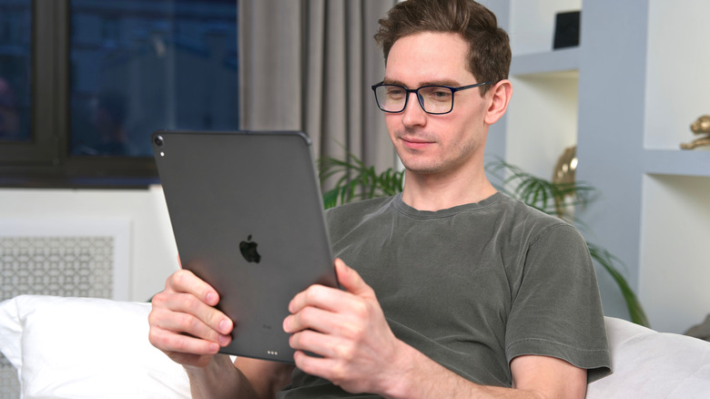 Man holding iPad in hands and looking at it