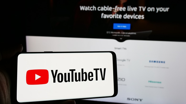 YouTube TV logo on a smartphone in front of TV