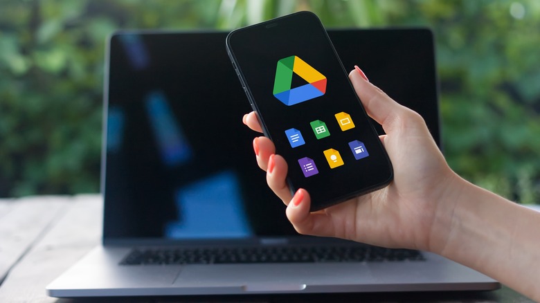 hand holding smartphone with Google Drive logo on screen