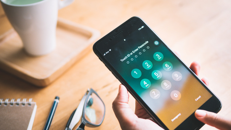 person holding iPhone with passcode