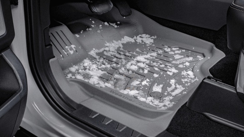 An image of a weathertech rubber floor mat inside a car with snow