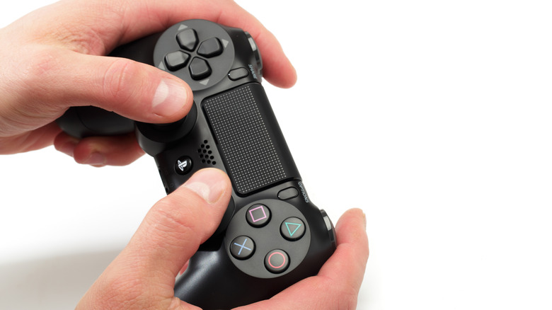 person holding black PS4 controller