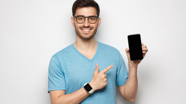 Smiling man holding iPhone