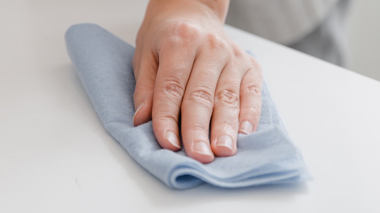 hand with blue microfiber cloth